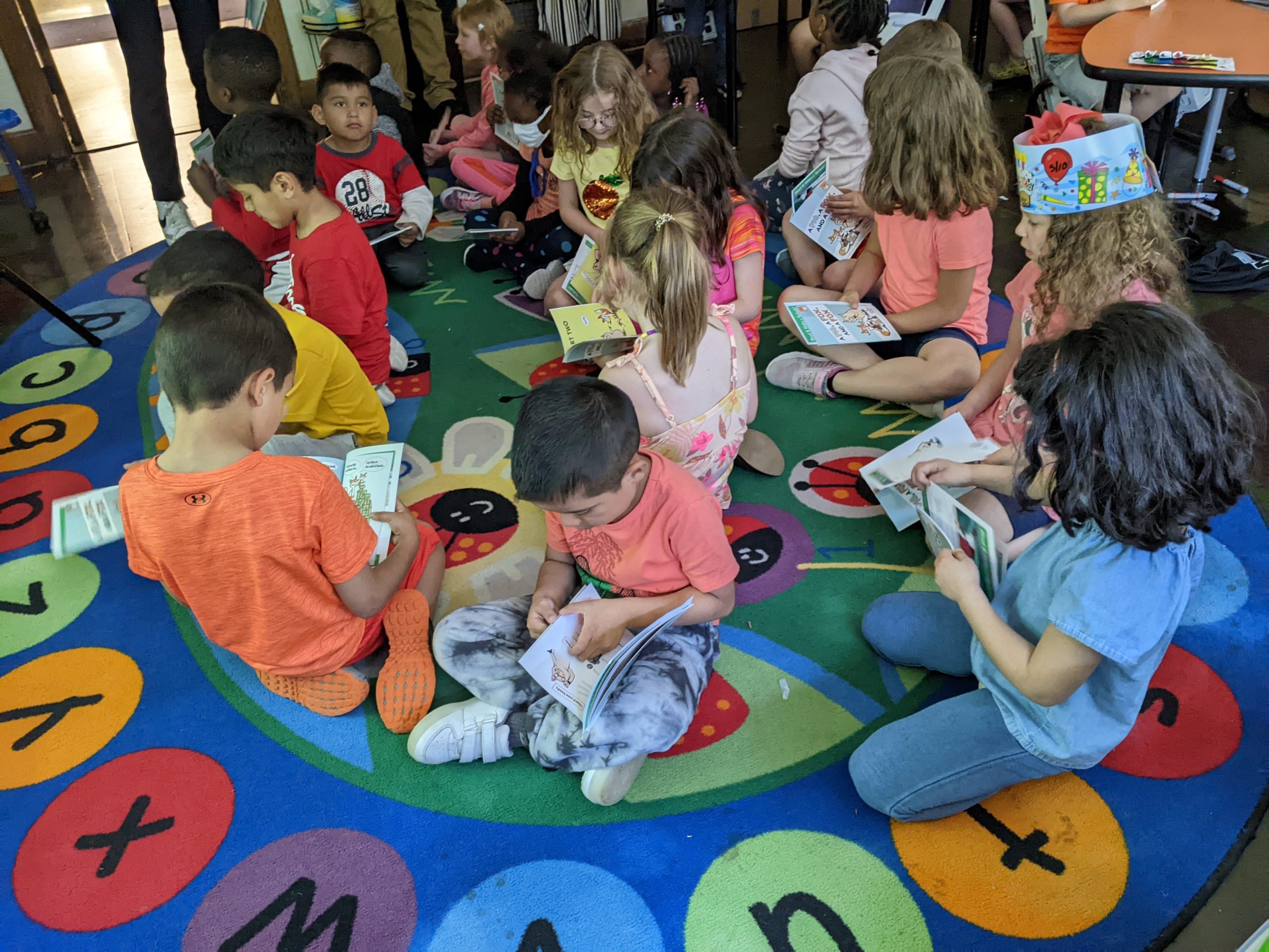 Photo of students at a Westerville school reading the new books they received from the library as a promotion for the summer reading challenge